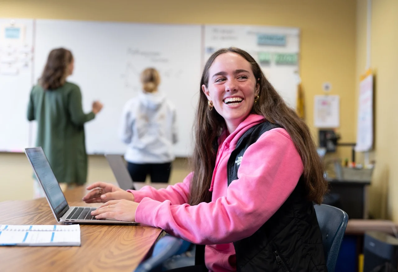 high school at table in math class smiling